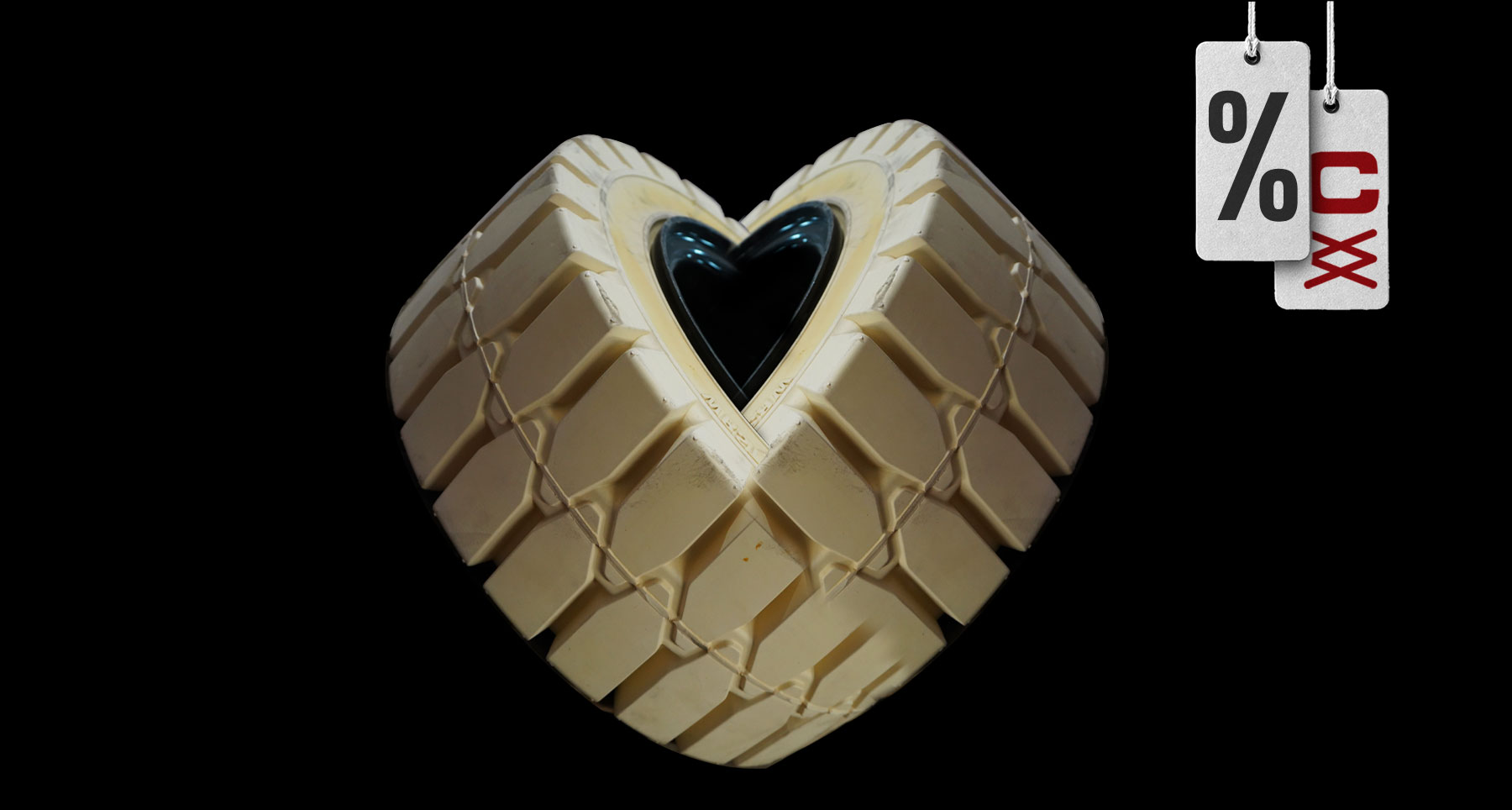 Neumático con forma de corazón en fondo neutro, imagen promocional de la oferta mensual de febrero.